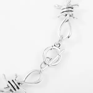 Detailed close-up of a silver hip hop rock barbed wire necklace with toggle clasp