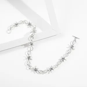 Close-up of silver hip hop barbed wire thorn necklace with OT clasp detail.