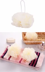 Gros plan sur une fleur de douche beige douce avec son cordon de suspension blanc