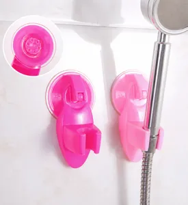 Detailed view of pink suction cup shower head bracket mounted on tiled bathroom wall