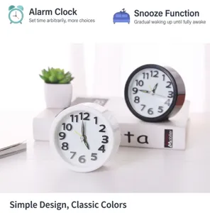 Detail view of modern minimalist round alarm clocks in black and white with luminous hands.