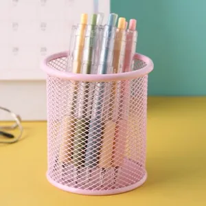 Nahaufnahme eines rosa Metallgitter-Stiftehalters mit Stiften auf dem Tisch.
