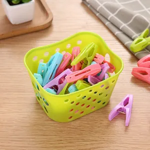 Set of 30 colorful plastic clothespins in a green storage basket for laundry drying