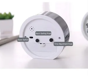 Macro detail of round alarm clock back featuring control knobs and battery compartment