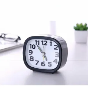 Close-up of minimalist black oval alarm clock with bold numeric display