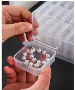Detail shot of a small transparent plastic jewelry box being opened by hands for storage