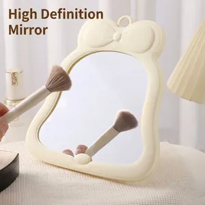 Cute bow-knot desktop makeup mirror with creamy white frame, ideal for dormitory vanity