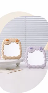 Close-up van schattige make-upspiegels in schaapvorm in beige en paars op een wit bureau