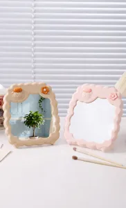 Gedetailleerd zijaanzicht van twee schattige schaapvormige make-upspiegels in roze en beige.