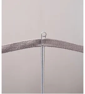 Macro view showing flexible spring threader pulling a flat grey fabric drawstring.