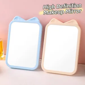 Cute cat-ear desktop makeup mirror in blue and beige, portable for vanity table use.