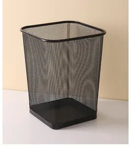 Detail view of a modern black iron mesh square trash can for office and home workspace