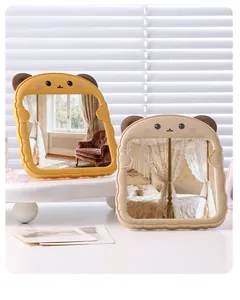 Nahaufnahme von zwei niedlichen Katzenohr-Tischspiegeln in Pastellgelb und Beige