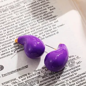 Gros plan sur des boucles d'oreilles goutte violettes brillantes