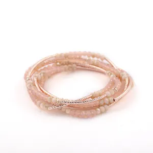 Detailed view of multilayer beaded bracelet with pink crystals and rose gold accents.