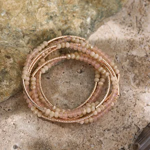 Close-up of multi-layer beaded crystal bracelet with rose gold textured tubes