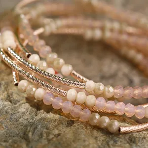 Close-up of multi-layered beaded bracelet with pink crystals and rose gold tubes