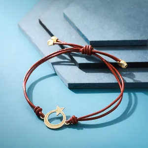 Primo piano del bracciale in corda rossa intrecciata a mano con ciondolo luna e stella