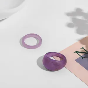 Detailed view of trendy purple acrylic rings set with marbled texture and glitter finish