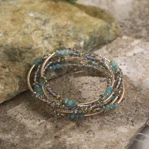 Detailed macro shot of multi-layer retro ethnic bracelet with teal beads and golden coils.