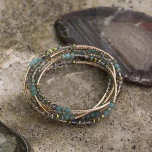 Detail showing multi-layer vintage bohemian crystal beaded bracelet on natural stone surface