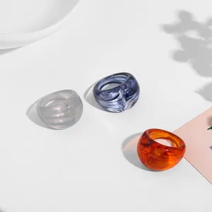 Detail view of chunky acrylic resin rings with marbled textures in various colors