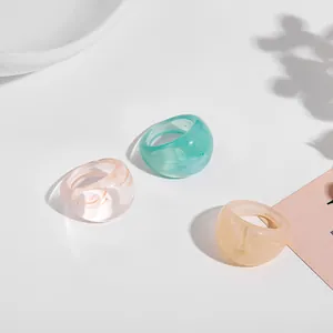 Close-up of three colorful chunky acrylic rings in green and marbled resin style