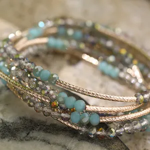 Close-up detail of multi-layer beaded bracelet with aqua and iridescent crystals
