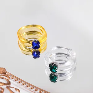 Detailed macro shot of trendy acrylic ring set featuring vibrant blue and green gemstones