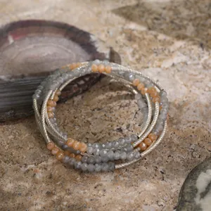 Detailed view of a retro ethnic multi-layer crystal bead bracelet on a natural stone.