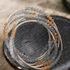 Macro detail of multi-layered beaded bracelet with grey crystals and silver metal tubes