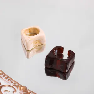 Detailed view of trendy acrylic rings with marble and tortoiseshell patterns