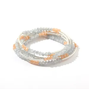 Detailed view of a multi-layer beaded bracelet with grey and peach crystal beads