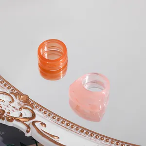 Detail shot of trendy colorful acrylic resin rings on a vintage mirror surface