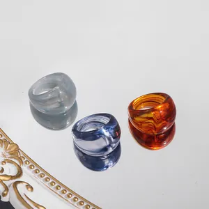 Close-up of three colorful marbled acrylic rings reflecting on a mirror surface