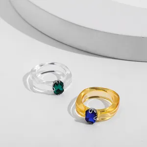 Close-up detail of trendy acrylic ring set featuring green and blue faceted gems