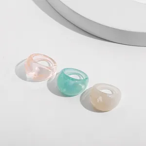 Detailed close-up showing three colorful acrylic rings with elegant marble texture pattern