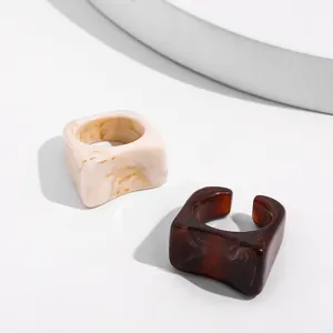 Detail of chunky acrylic ring set in marble cream and tortoiseshell brown finishes