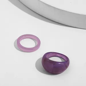 Detailed macro view of two trendy purple acrylic rings featuring a unique marble texture