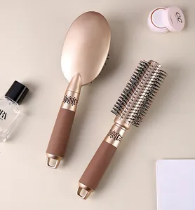 Top view of champagne gold paddle and round hairbrushes for professional styling