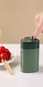 Detail shot showing the press-to-eject mechanism of the green toothpick dispenser