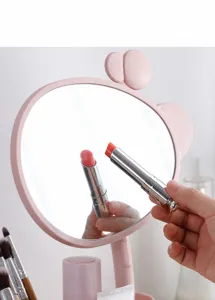 Primer plano de espejo de maquillaje rosa estilo jirafa con reflejo muy nítido