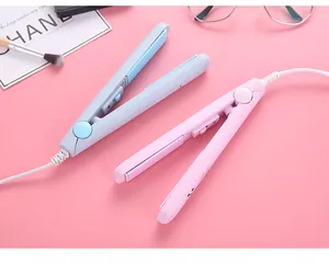 Close-up detail of mini pastel pink and blue hair straighteners on a soft pink background
