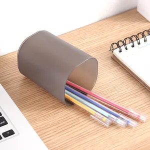 Matte doorschijnende grijze pennenhouder met gekleurde gelpennen op houten bureau