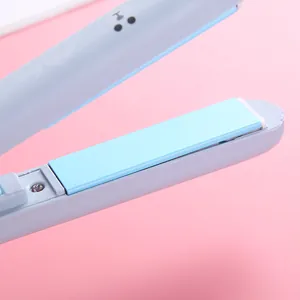 Close-up of a mini portable electric hair straightener flat iron in light blue