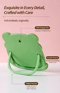 Back view of green frog-shaped makeup mirror showing wall-hanging hole and stand