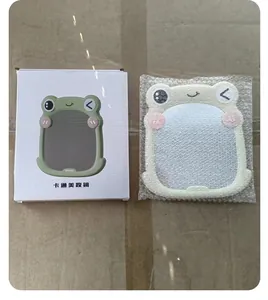 Close-up detail view of the cute cartoon frog makeup mirror alongside its retail packaging box