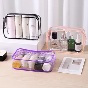 Three-piece set of transparent PVC travel toiletry bags with colorful zipper borders.