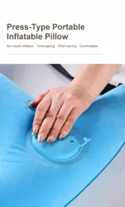 Detalle de la bomba de inflado manual por presión en una almohada de viaje azul para coche.