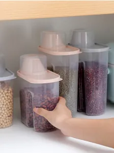 Close-up of a hand grabbing a moisture-proof cereal storage container in a kitchen cabinet